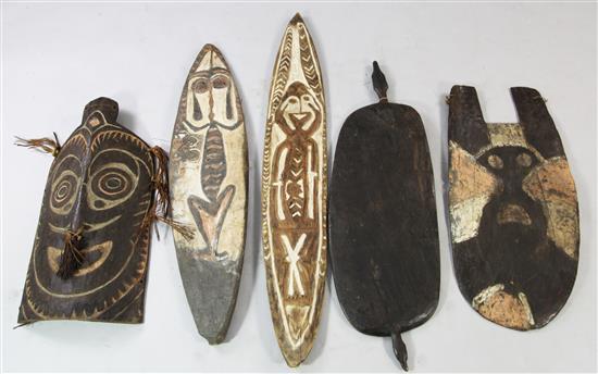 A Sepik River archers shield, another shield and three carved boards